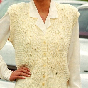 May include: A white knitted sleeveless vest with a cable knit pattern and button closure.