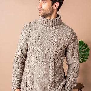 Könnte beinhalten: Ein beiger Rollkragenpullover mit einem Zopfmuster. Der Pullover hat eine lockere Passform und lange Ärmel.