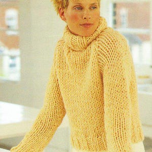 Pode incluir: Um suéter de malha grossa amarelo claro com gola alta canelada. O suéter tem mangas compridas e bainha canelada. A malha parece ser feita de um fio macio e quente, perfeito para climas mais frios. O estilo geral é casual e confortável.