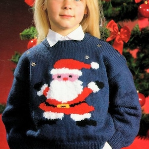 May include: A blue knitted jumper with a white, red and black Santa Claus design. The jumper has a white collar and is decorated with silver snowflakes.