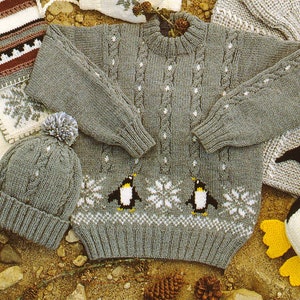 May include: A gray knitted sweater with a cable knit pattern and penguin designs. The sweater has a white pom-pom on the hat.