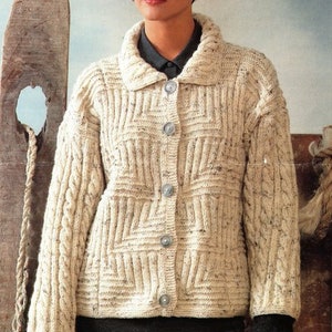 May include: A cream-coloured knitted cardigan with a cable knit pattern and a button-up front. The cardigan has a wide collar and long sleeves.