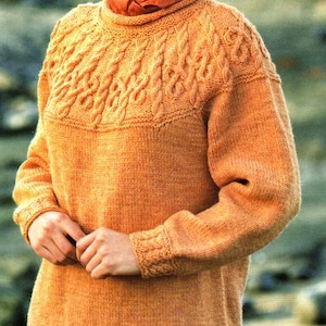Peut inclure: Un pull en tricot orange chaud avec un motif en câble autour de l'encolure et de l'ourlet. Le pull a des manches longues et une coupe ample.