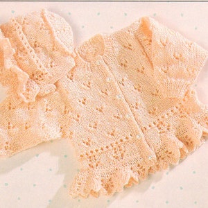 Puede incluir: Un delicado conjunto de cardigan y gorro para bebé, tejido a crochet en un color rosa pálido. El cardigan presenta un patrón de encaje y un cierre de botón. El gorro tiene un diseño de encaje a juego.