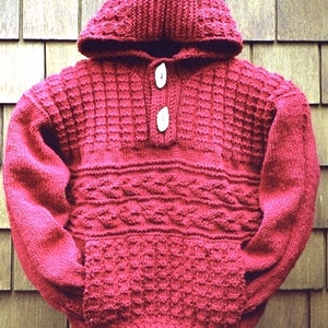 May include: A red knitted hooded sweater with a button fastening and a cable knit pattern.
