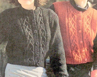 May include: Two women wearing knitted cardigans. The woman on the left is wearing a black cardigan with a cable knit pattern and buttons. The woman on the right is wearing a red cardigan with a cable knit pattern and buttons.