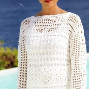 Peut inclure: Top en crochet blanc à la coupe ample et aux manches longues. Le haut présente un motif ajouré délicat et un col bateau.