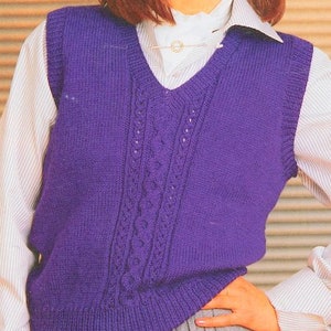 以下が含まれることがあります： ケーブル編みのパープルのニットベスト。ベストはVネックでノースリーブです。