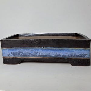 May include: A set of three ceramic mugs with a speckled, matte finish. The mugs are in shades of cream, light gray, and dark gray. Each mug has a simple, minimalist design, perfect for coffee or tea.