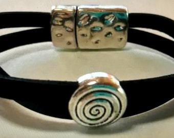 May include: A black leather bracelet with a silver magnetic clasp and a silver spiral charm.