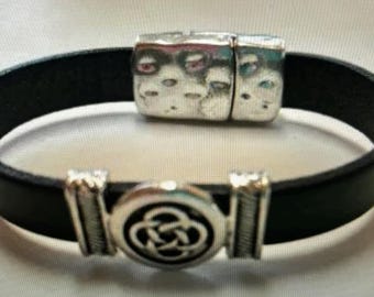 May include: A black leather bracelet with a silver magnetic clasp and a silver Celtic knot charm.