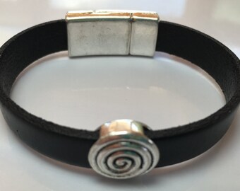 May include: A black leather bracelet with a silver magnetic clasp and a silver spiral charm.