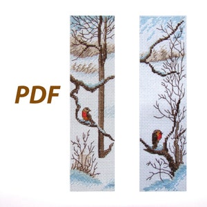Puede incluir: Dos patrones de punto de cruz que representan escenas de invierno con pájaros. Los patrones están sobre un fondo blanco con acentos azules y marrones. El primer patrón muestra un pájaro posado en una rama en un bosque nevado. El segundo patrón muestra un pájaro posado en una rama en un campo nevado.