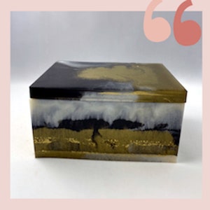 May include: A rectangular box with a black, white, and gold abstract design. The box is made of resin and has a glossy finish.