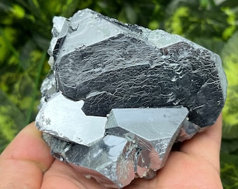 May include: A cluster of metallic gray pyrite crystals with sharp, geometric facets. The crystals are arranged in a random, natural formation.