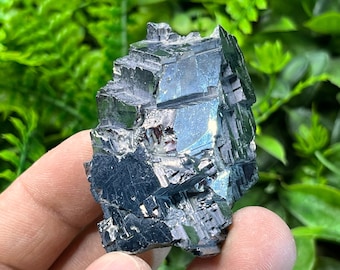 May include: A cluster of black Hematite crystals with a metallic sheen. The crystals are sharp and angular, with a rough texture.