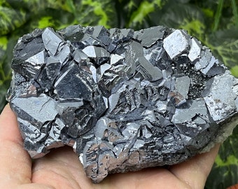 May include: A cluster of metallic gray galena crystals with a sharp, geometric shape. The crystals are intergrown and have a reflective surface.