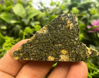May include: A green and yellow crystal cluster with a rough, textured surface. The crystal is a natural formation with a unique shape.