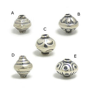 May include: Five silver beads with different embossed designs. The beads are round and have a hole in the centre. The beads are labelled A, B, C, D, and E.