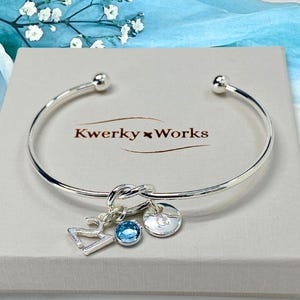 21st birthday gift bracelet for women. Adjustable silver-plated friendship knot bracelet with silver plated 21 charm, initial letter charm and choice of birthstone crystal colour to suit the birth month