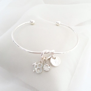 18th birthday gift bracelet for women. Adjustable silver-plated friendship knot bracelet with silver plated 18 charm, initial letter charm and choice of birthstone crystal colour to suit the birth month