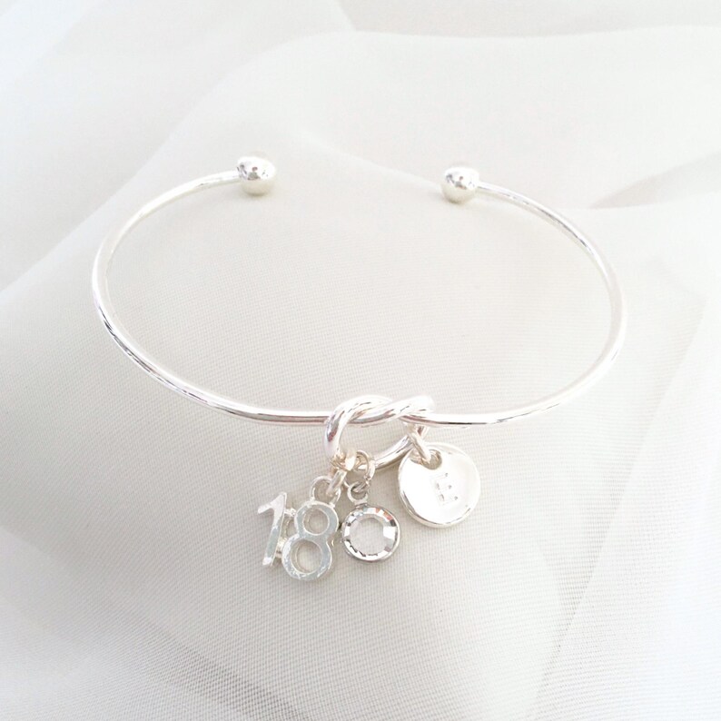 18th birthday gift bracelet for women. Adjustable silver-plated friendship knot bracelet with silver plated 18 charm, initial letter charm and choice of birthstone crystal colour to suit the birth month