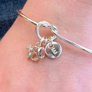 18th birthday gift bracelet for girls, being worn to show how the bracelet fits onto the 18 year old's wrist and shows the way the crystal, initial and number charm naturally hang from the knot of the bracelet.