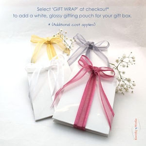 This picture shows the ribbon tied glossy white gift pouch that you can add to your order (additional cost applies), if you want the bracelet and gift box gift wrapped. To add this extra option, click 'gift wrap' at checkout. Charge applies to ONE gift pouch per order.