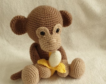 Milo the monkey with a banana. Handmade crochet soft toy.