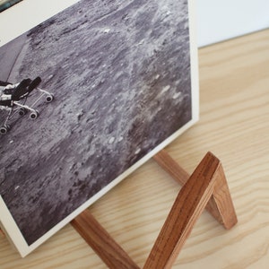 May include: A wooden record stand with a dark brown stain. The stand is holding a vinyl record with the text "SPACE IS ONLY NOISE" on the cover.