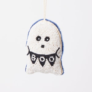 May include: White beaded ghost ornament with a black beaded "BOO" banner. The ghost has black eyes and a mouth.