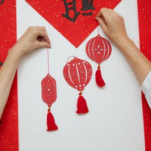 Handmade red paper lantern ornaments set of three with tassel details, inspired by Lunar New Year traditions and festive spring celebration décor.