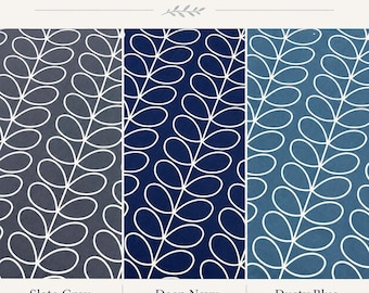 Op de afbeelding: Afbeelding met drie stofstalen met een herhalend bladpatroon in leisteengrijs, diep marineblauw en stoffig blauw. De tekst "AVAILABLE COLORS" staat bovenaan. Elke staal heeft een witte omtrek van het bladontwerp.