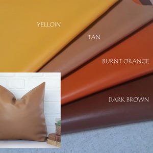May include: A tan cushion with a smooth surface is shown against a white brick wall. The image also displays swatches of yellow, tan, burnt orange, and dark brown leather, with the colours labelled.