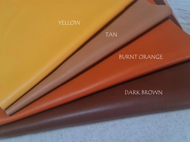 May include: Four fabric swatches in yellow, tan, burnt orange, and dark brown are displayed. The colours are labelled with white text. The material appears to be leather or a leather-like fabric.