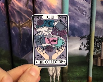 May include: A tarot card with the number XCIX and the words "The Collector" printed on it. The card features a pile of books with a rose and a crescent moon on top. Two hands are reaching up to hold the books.