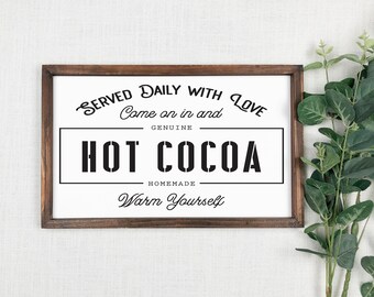 May include: A brown wooden framed sign with a white background and black text that reads "Served Daily With Love Come on in and Genuine Hot Cocoa Homemade Warm Yourself".