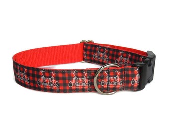 May include: Red and black plaid dog collar with the words "Merry Christmas" and reindeer silhouettes. The collar has a black plastic buckle and a silver metal ring for leash attachment. The inside of the collar is solid red.