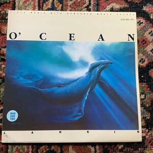May include: Vinyl record cover featuring a blue whale swimming in a blue ocean with the title "O'CEAN" and the text "FLUTE MUSIC WITH HUMPBACK WHALE SOUNDS (OH-SEE-ON)".