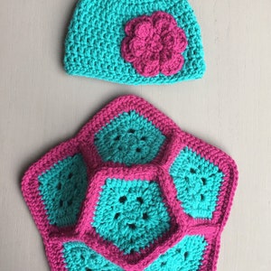 May include: A crocheted hat and a star-shaped crocheted blanket in teal and pink.