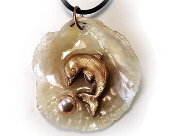 Beach treasury pendant, handmade goldcolor bronze Dolphin, freshwater pearl cab on a transluscent anomia shell , black leather strap