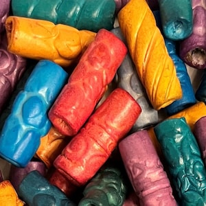 Puede incluir: Una colección de cuentas de madera de colores, cada una con un diseño tallado único. Las cuentas son en tonos de azul, verde, morado, rojo y amarillo.