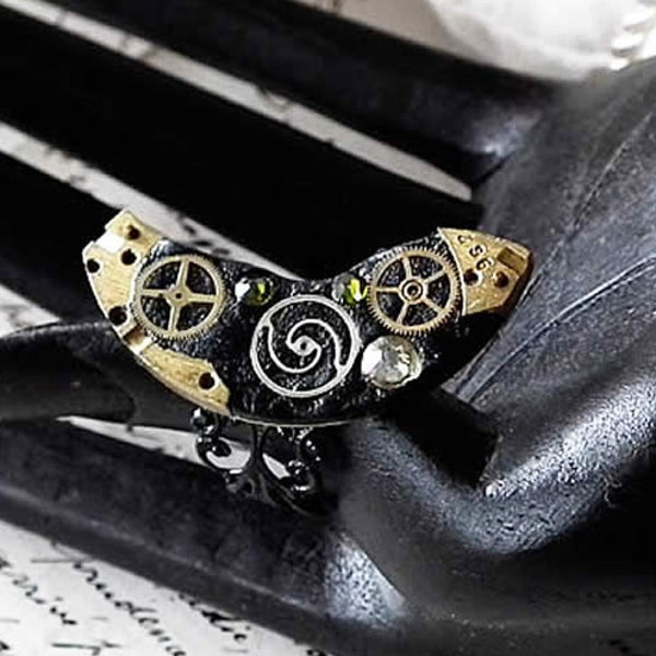 Bague steampunk Klimtienne ajustable, monture filigranée et pièces+rouages de montre+Cristaux Swarovski verts, résine polymère noire