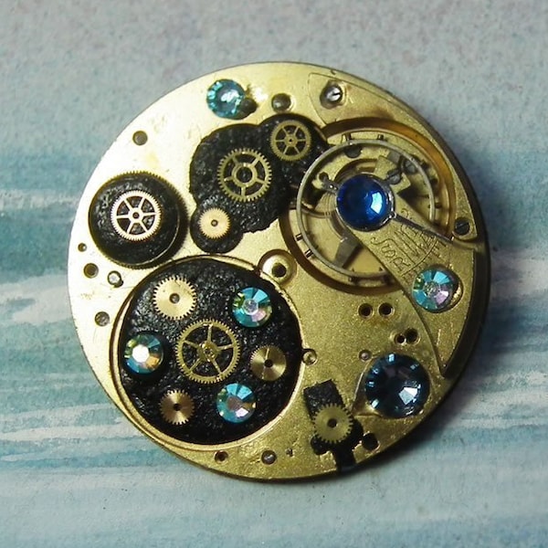 Broche/pendentif Steampunk klimtien. mécanisme+rouages de montre,  cabochons Swarovski,   cuir noir