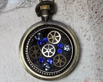 Unisex steampunk pendant, little bronze colour watchcase, cogs, black resin and blue swarovski crystals, black leather cord