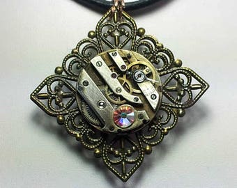 Steampunk  pendant, bronze colour filigree stamping, watch mecanism, Swarovski crystal cab , pink glass cab and  a  black leather  strap