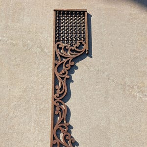 May include: A decorative, ornate, wooden architectural element with a dark brown, weathered finish. The design features a repeating grid pattern at the top and bottom, with a scrolling, floral-inspired pattern along the side. The piece is approximately 40 inches long.