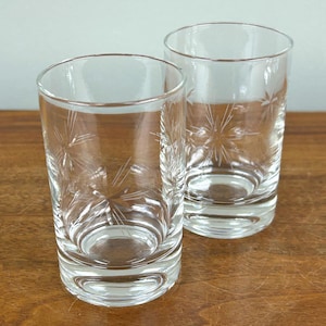 May include: A set of three ceramic mugs with a speckled, matte finish. The mugs are in shades of cream, light gray, and dark gray. Each mug has a simple, minimalist design and a rounded handle.