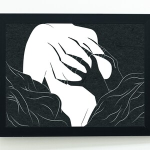 May include: Black framed art print featuring a stark, minimalist design. The artwork depicts a white form with claw-like hands reaching out from a dark, textured background. The contrast between the white and black creates a striking visual.