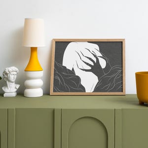 May include: A modern interior scene features a green cabinet with a white bust, a yellow and white lamp, and a framed black and white art print. A yellow planter with greenery adds a pop of color.
